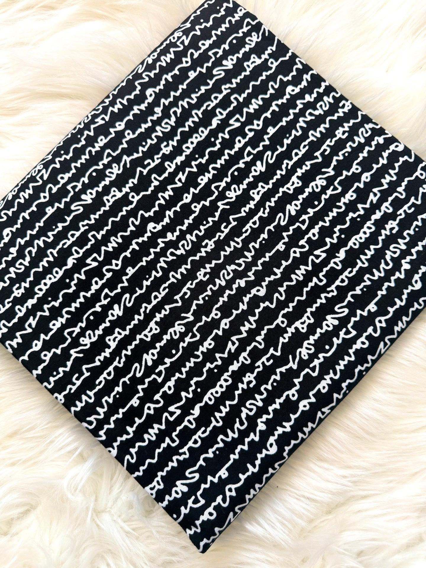Black and white patterned fabric on a fluffy white surface
