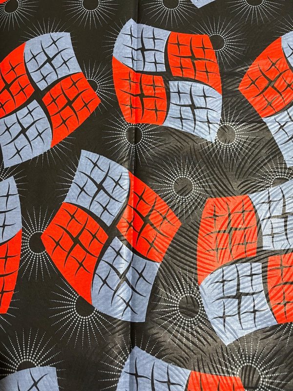 Fabric with geometric pattern featuring red, blue, and gray shapes on a black background