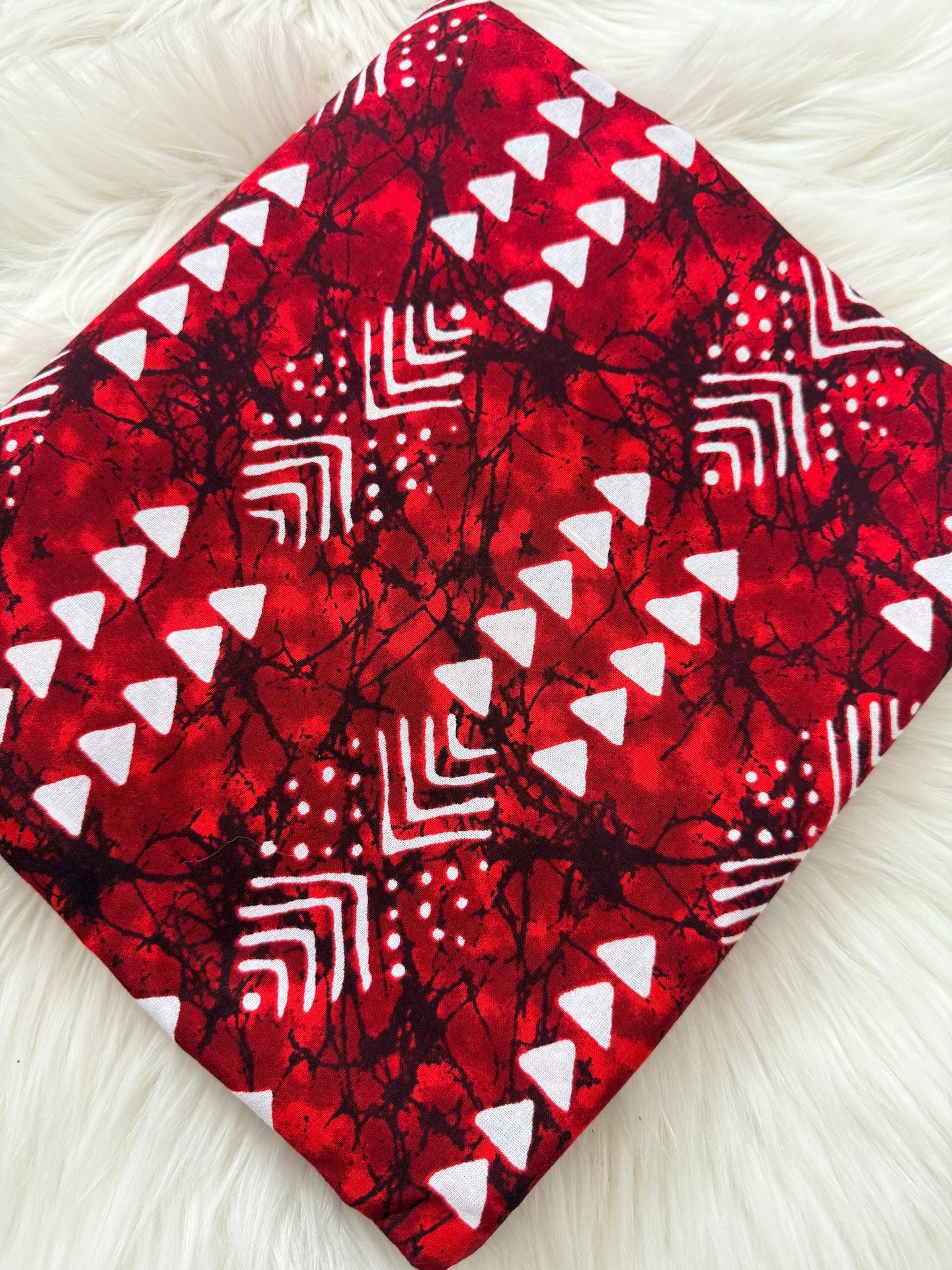Red fabric with white geometric patterns on a white background