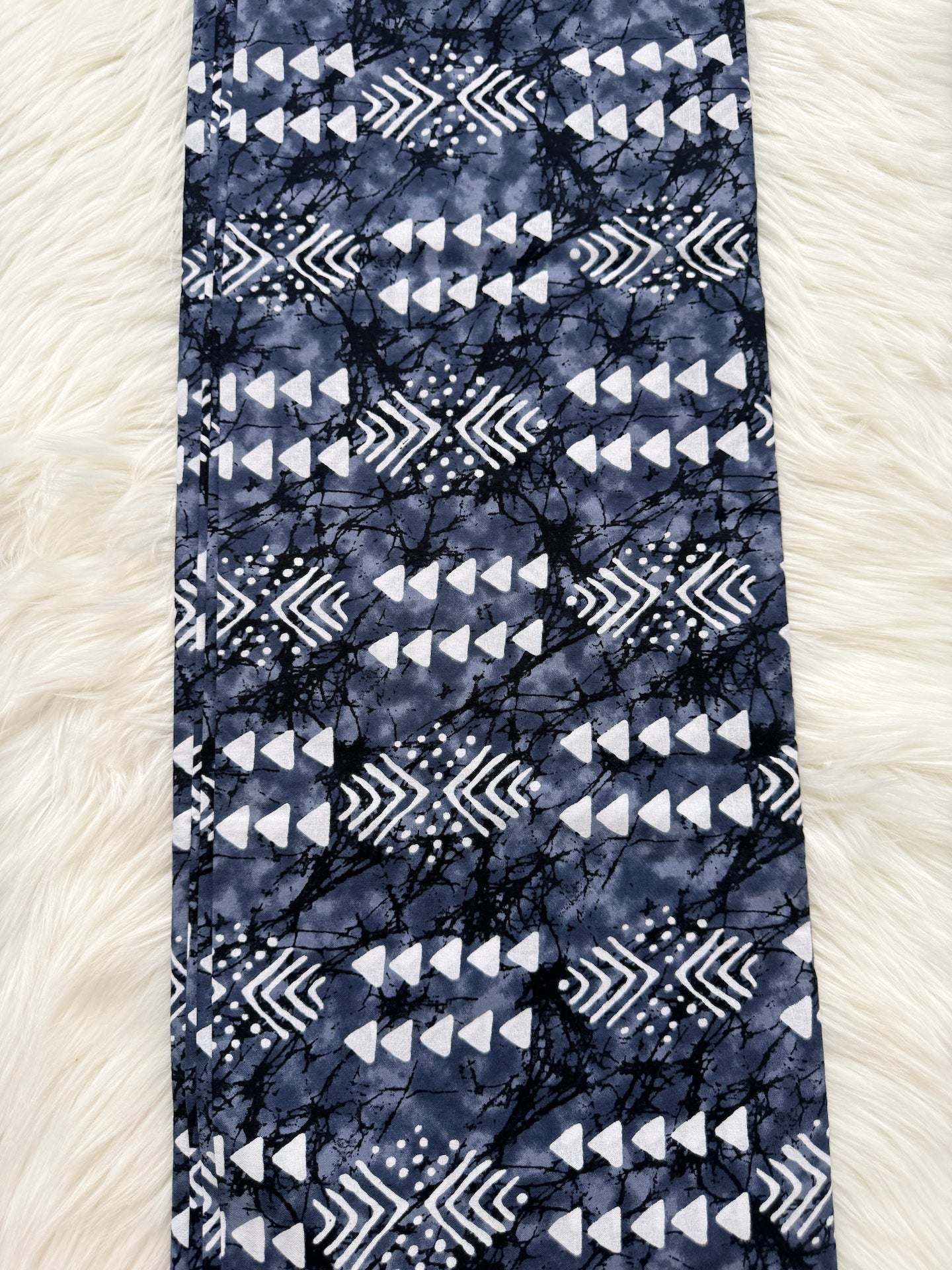 Blue and white patterned fabric on a textured white surface