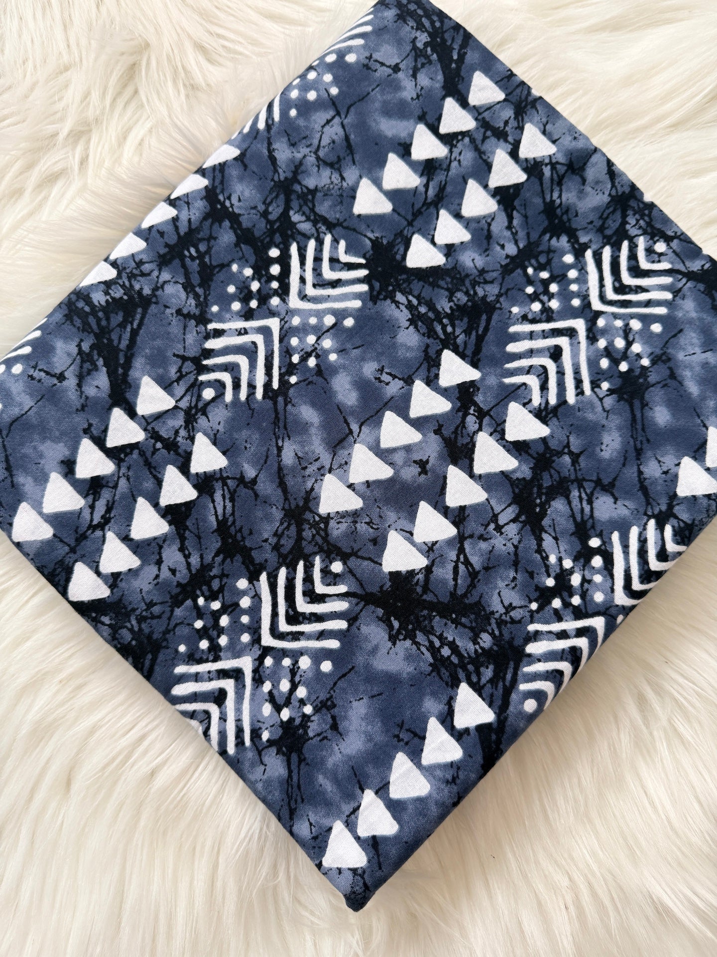 Blue fabric with white geometric patterns on a fluffy white surface