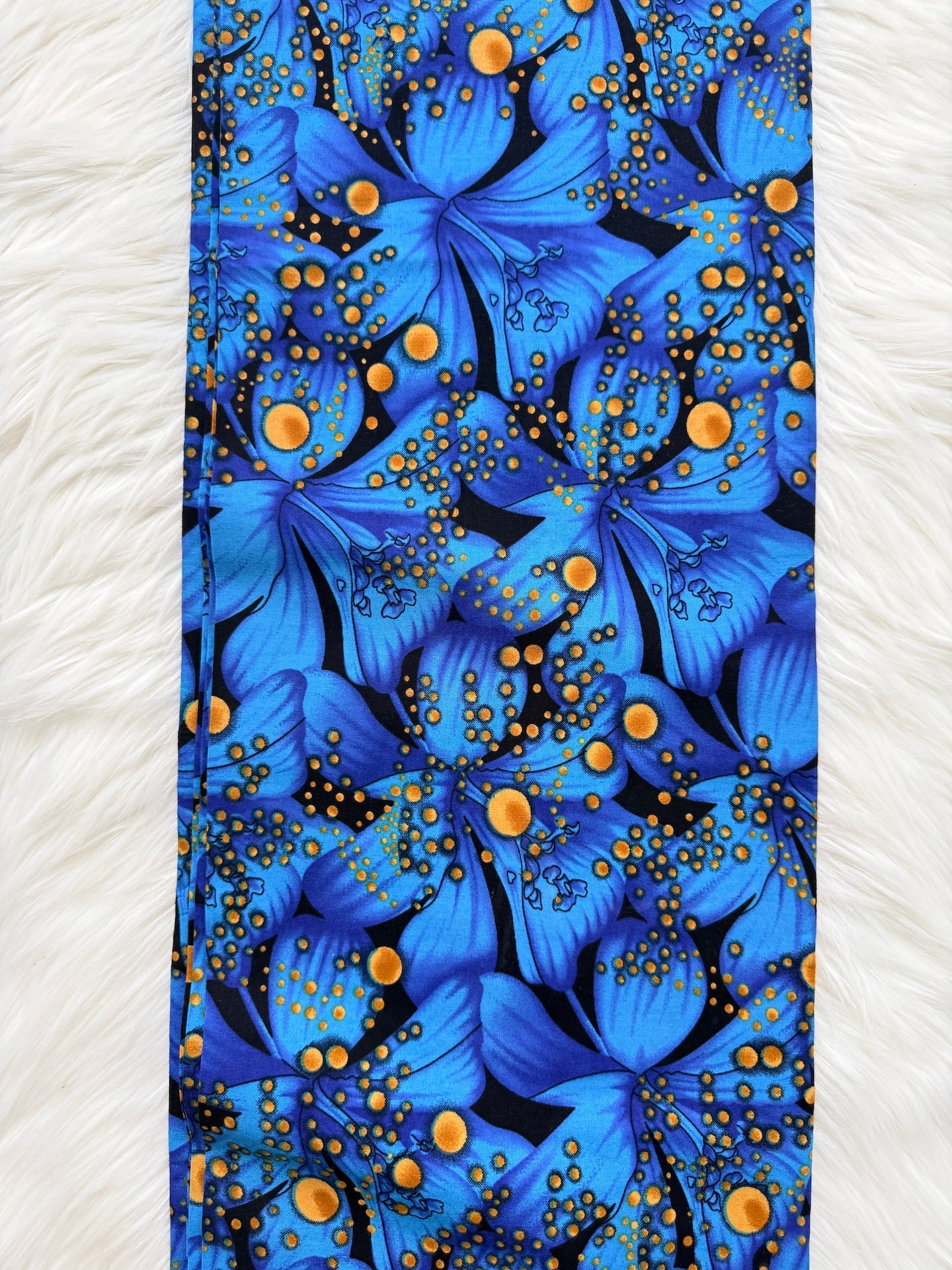 Blue floral patterned fabric with gold accents on a white background
