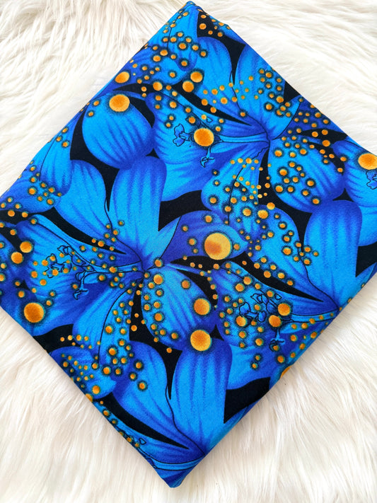 Blue floral fabric with orange accents on a white fluffy surface