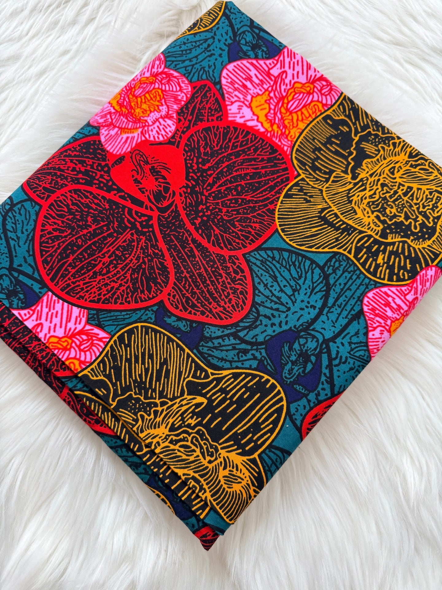 Colorful floral patterned fabric on a white fluffy surface