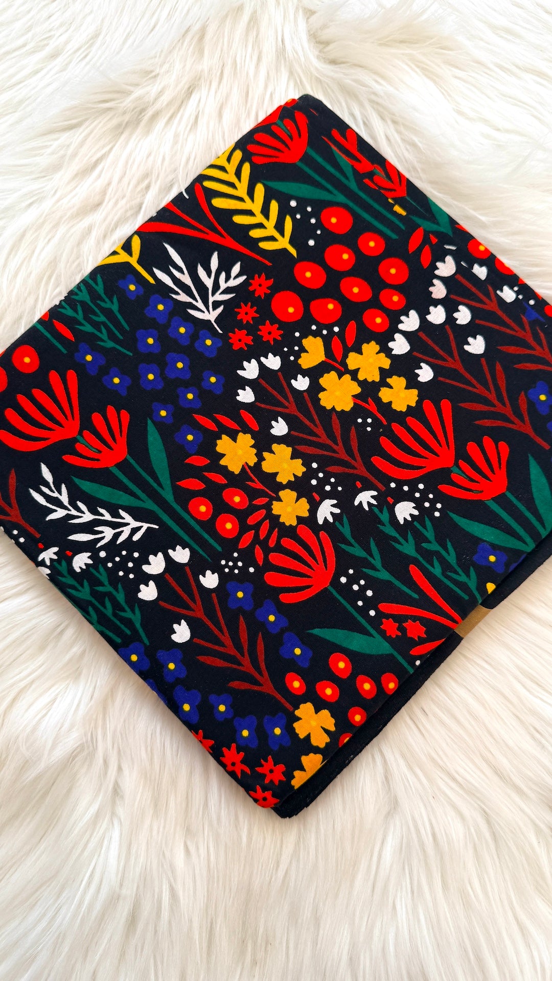 Colorful floral patterned fabric on a white fur background