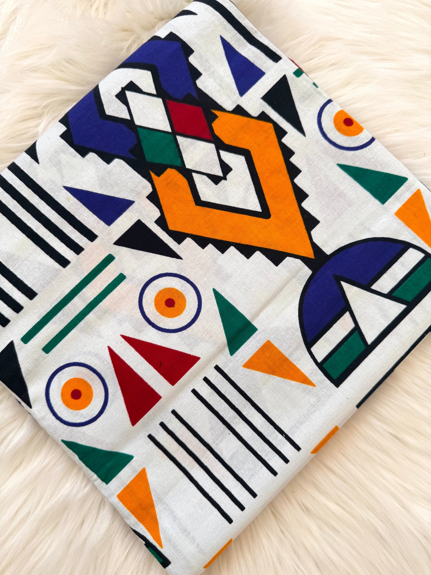 Colorful geometric patterned fabric on a light wooden surface