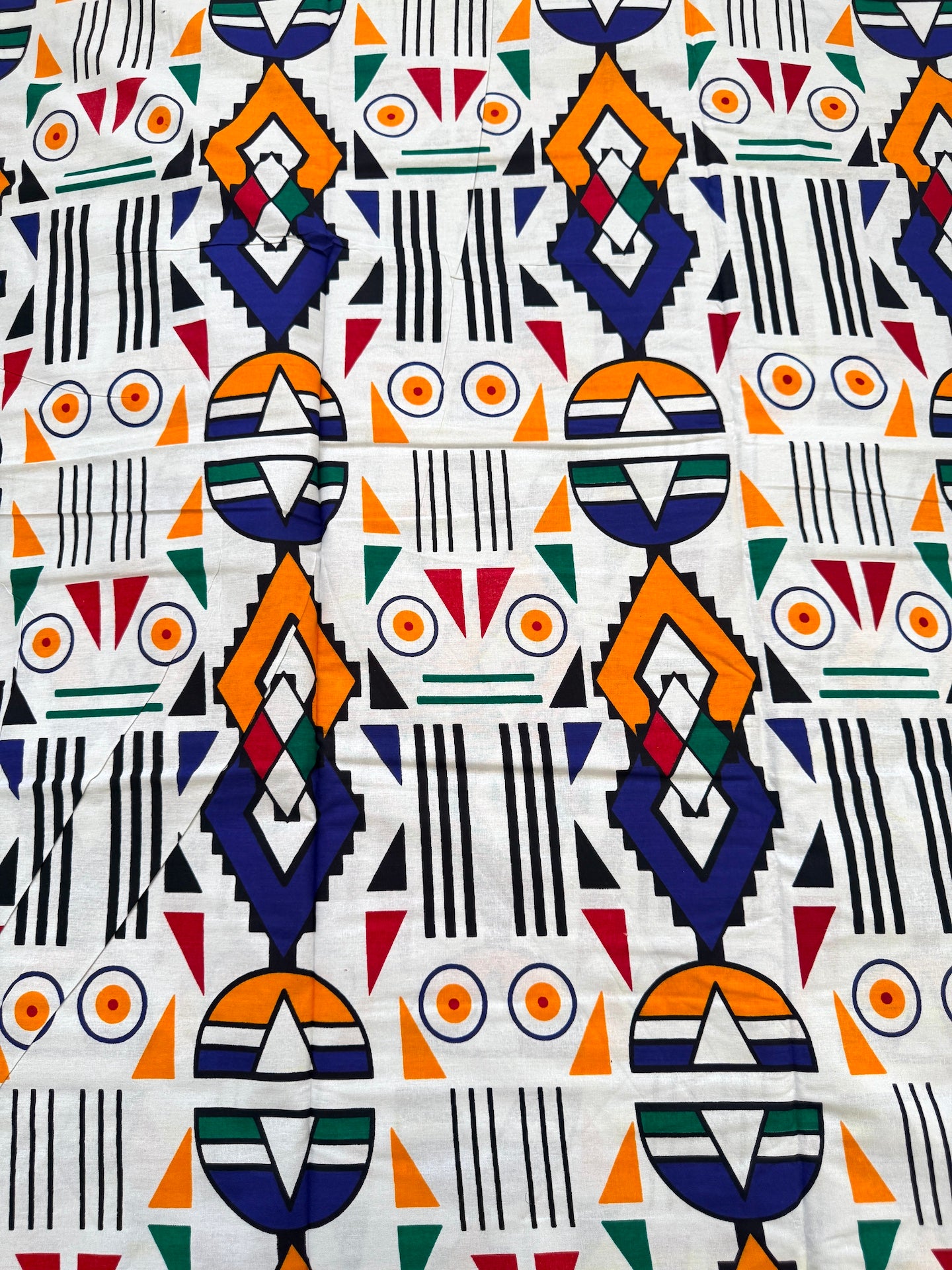 Patterned fabric with geometric shapes in various colors on a white background