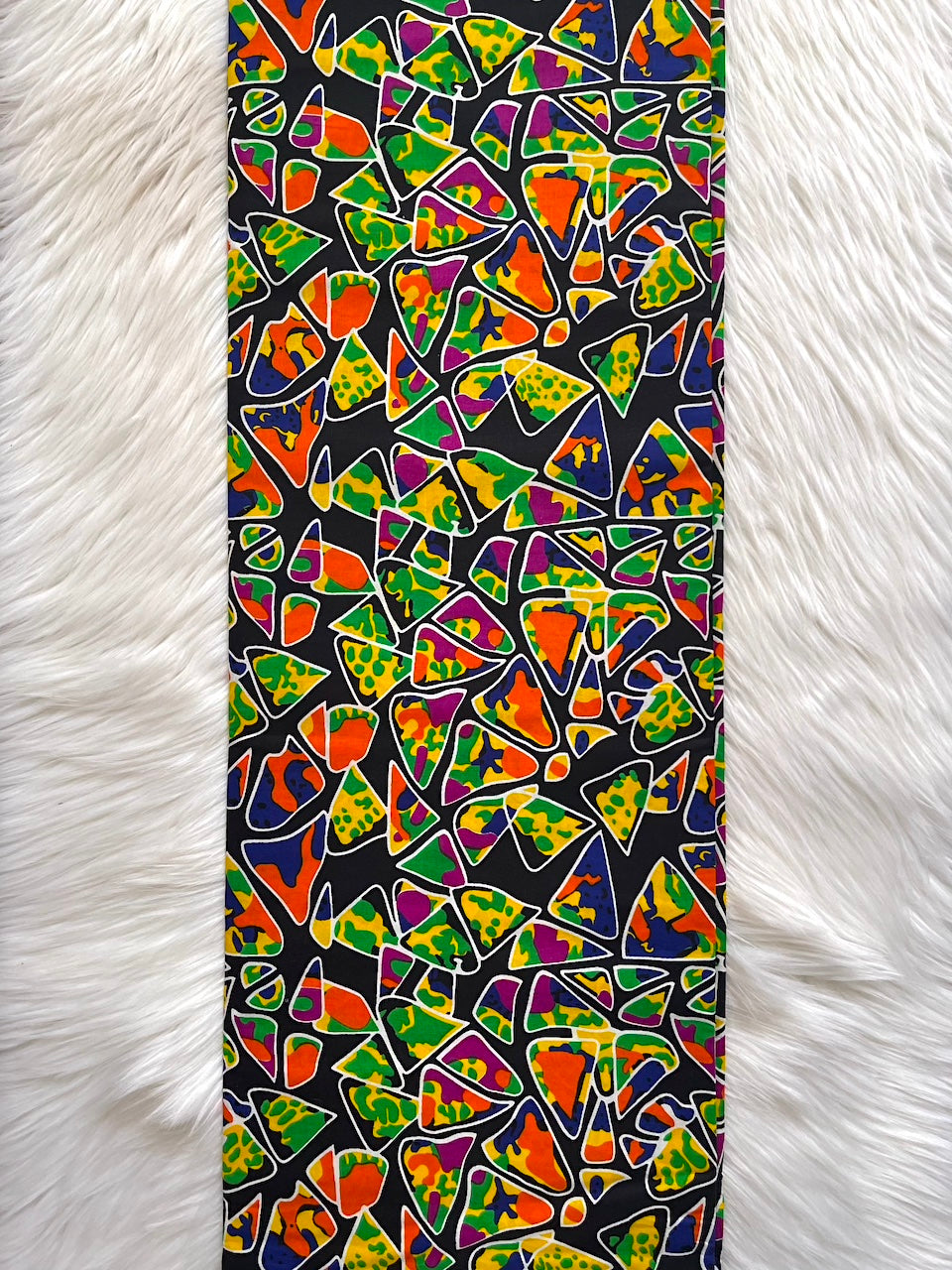 Colorful geometric patterned phone case on a white fur background
