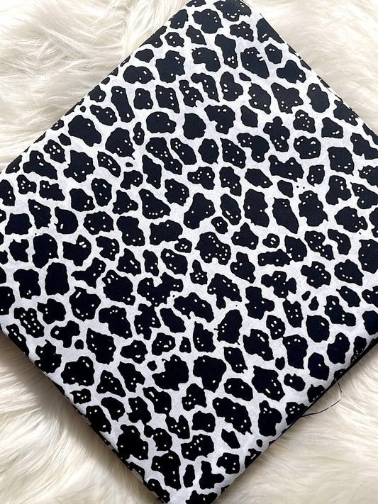 Black and white leopard print pattern on a textured surface