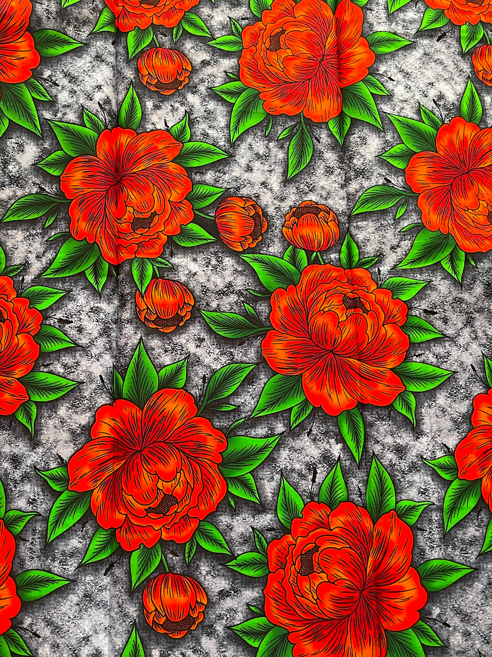 Pattern of orange flowers with green leaves on a textured gray background