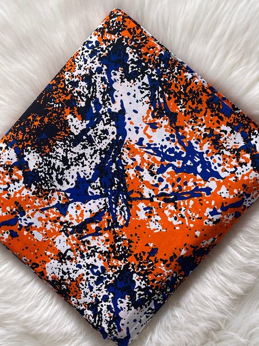 Fabric with orange, blue, and white abstract pattern on a white surface