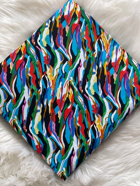 Colorful wavy patterned fabric on a white fluffy surface