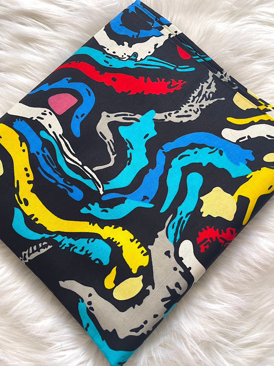 Colorful abstract patterned fabric on a white fluffy surface