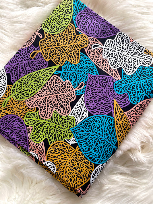 Colorful leaf-patterned fabric on a white fluffy surface