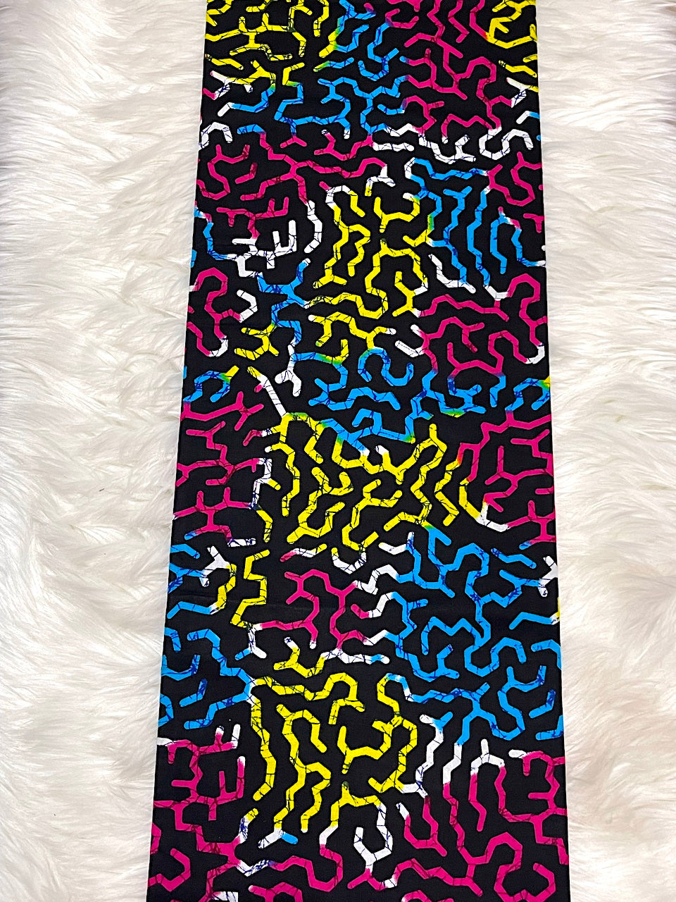 Colorful patterned fabric on a white fur background