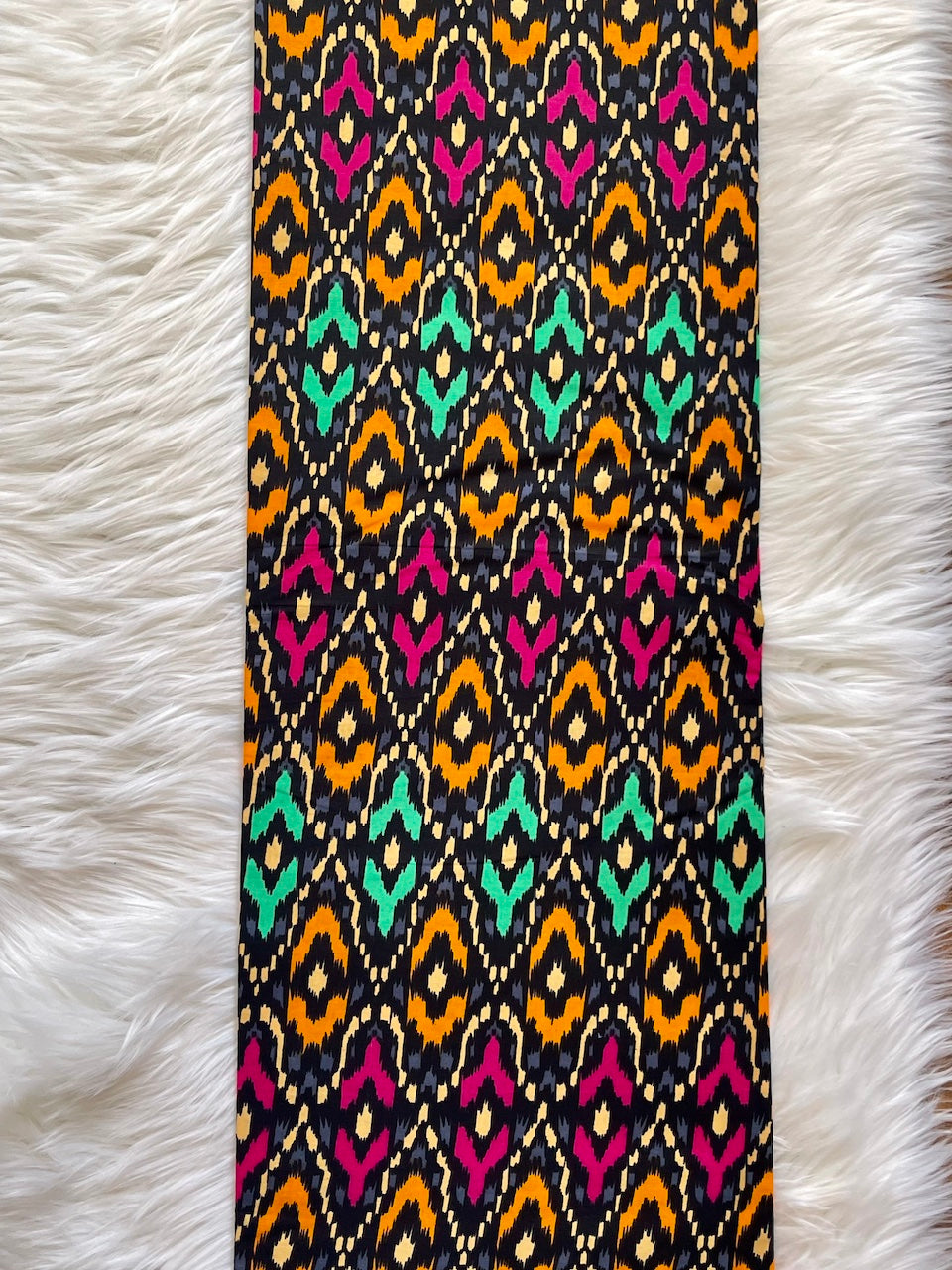 Colorful patterned fabric on a white fur surface