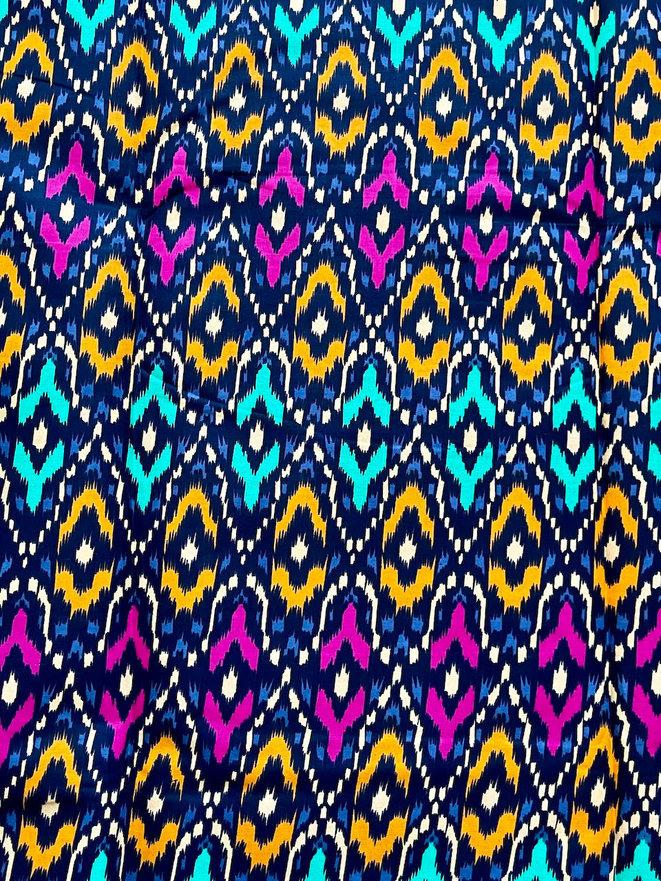 Colorful geometric pattern with blue, yellow, pink, and white on a dark blue background