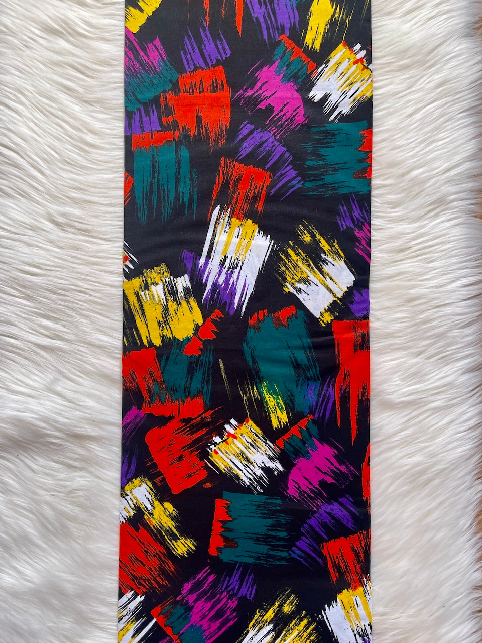 Colorful abstract patterned fabric on a white textured surface