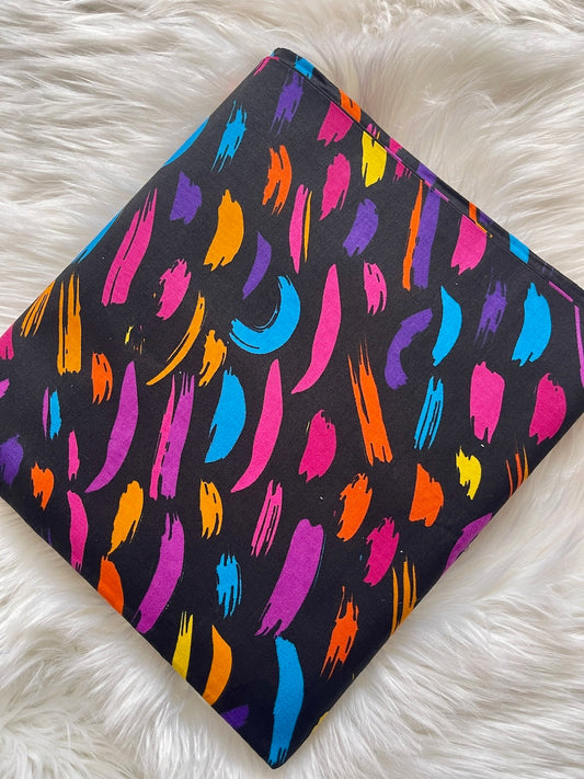 Colorful abstract pattern on a black background on a white fluffy surface
