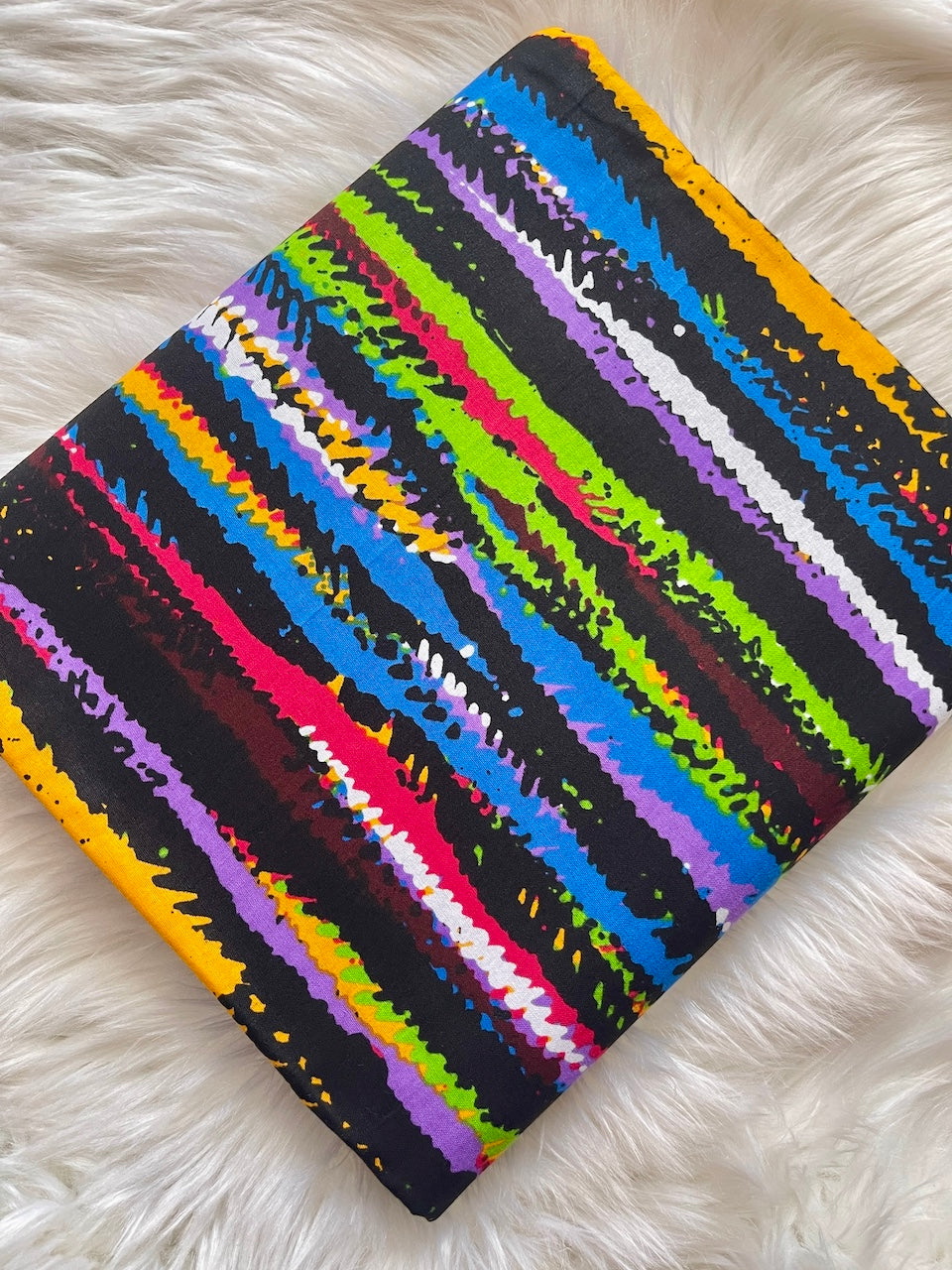 Colorful striped fabric on a white fluffy surface