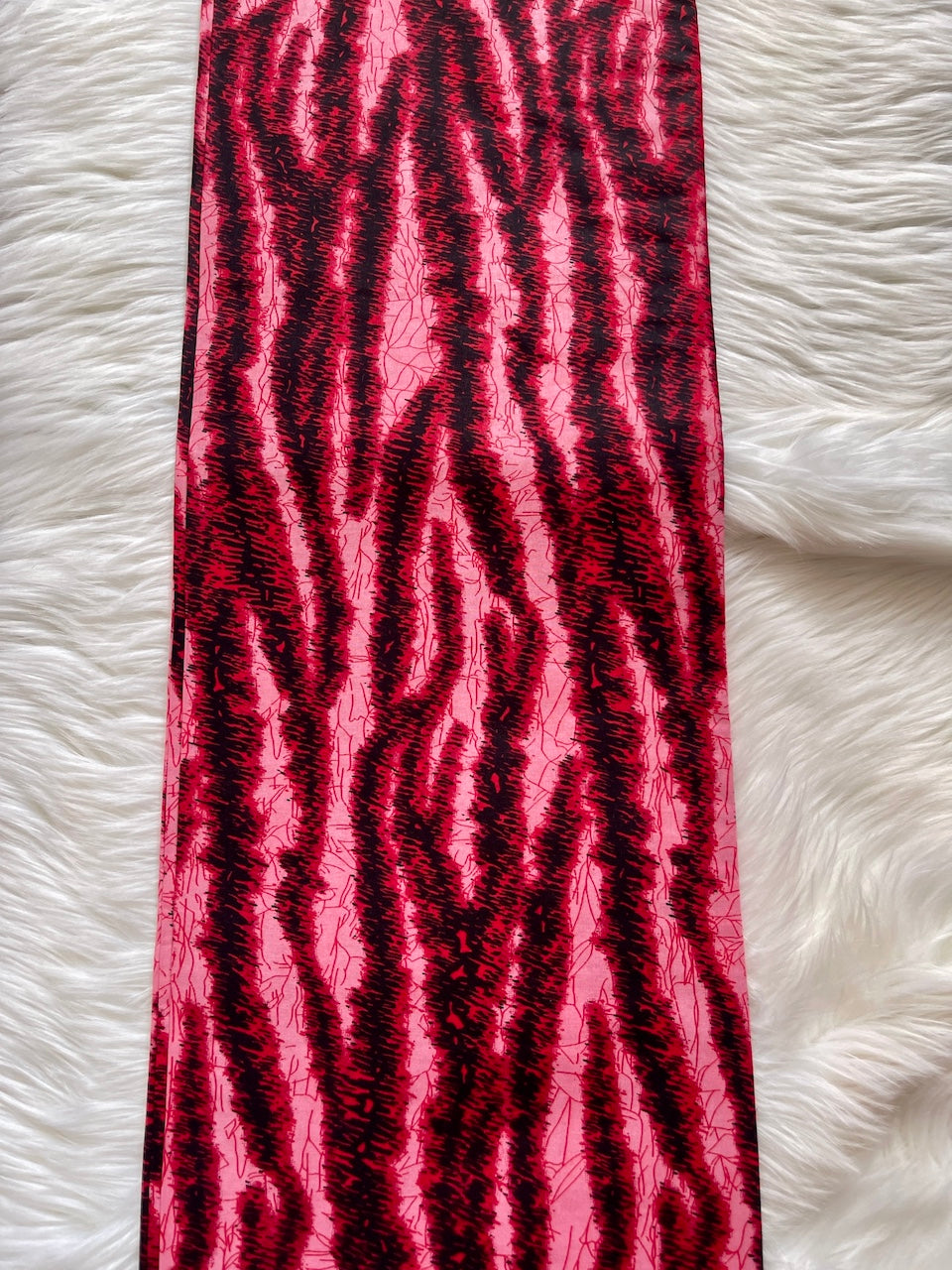 Pink and black patterned fabric on a white fluffy surface