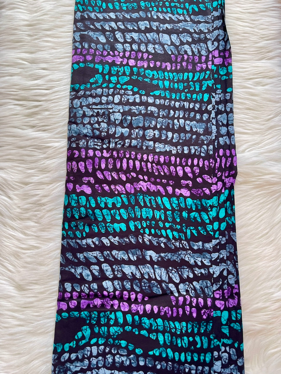 Patterned fabric with blue and purple design on a white textured background