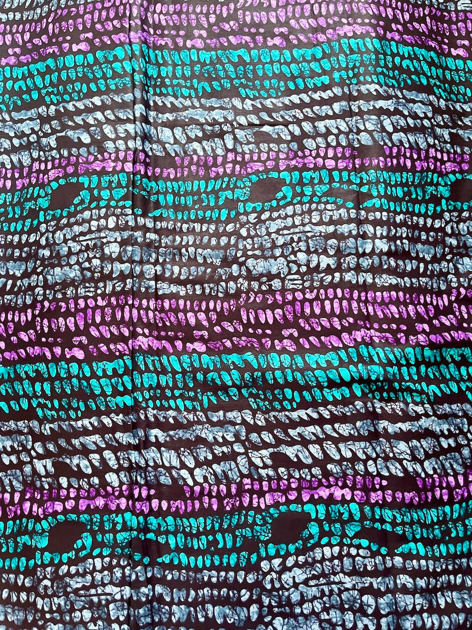 Textured fabric with a pattern of wavy lines in purple, blue, and black.