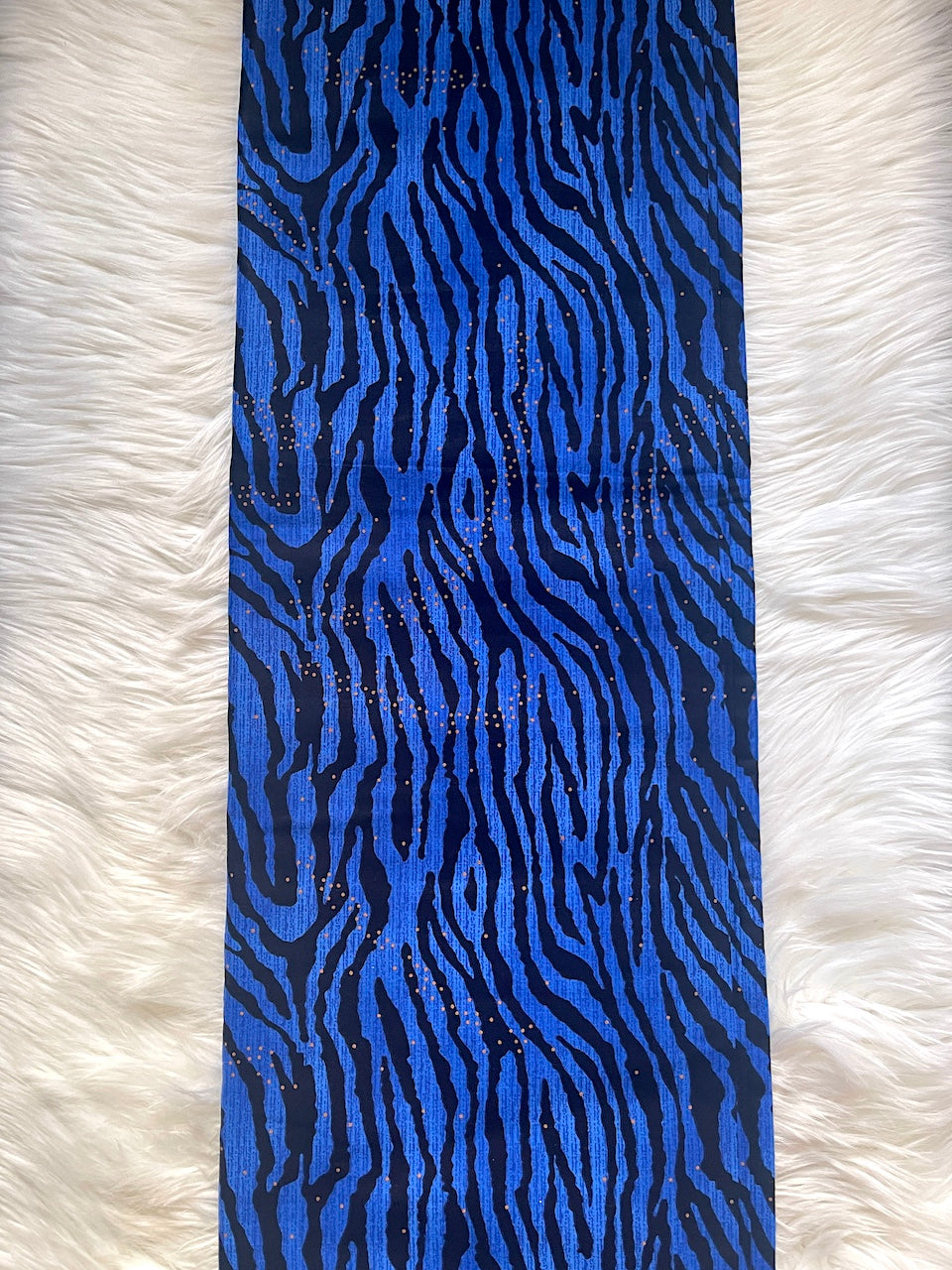 Blue and black zebra patterned fabric on a white textured background