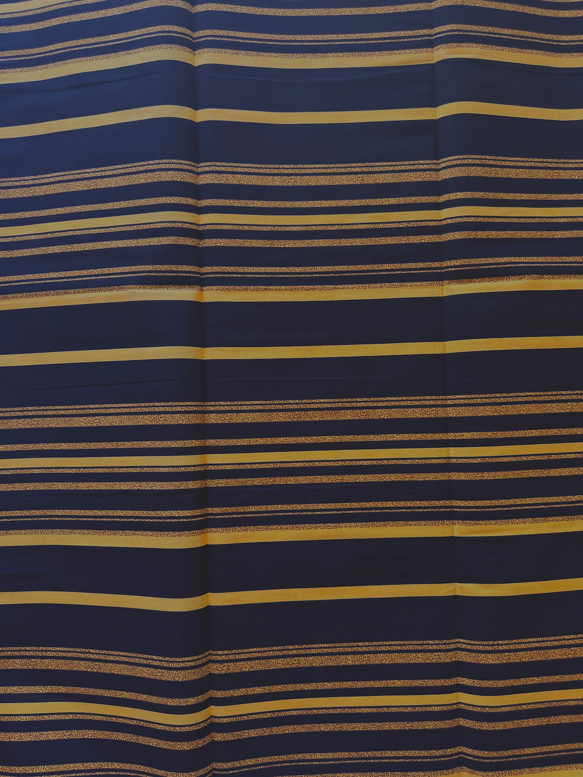 A close-up of a striped fabric with horizontal bands of navy blue, mustard yellow, and thin beige stripes.