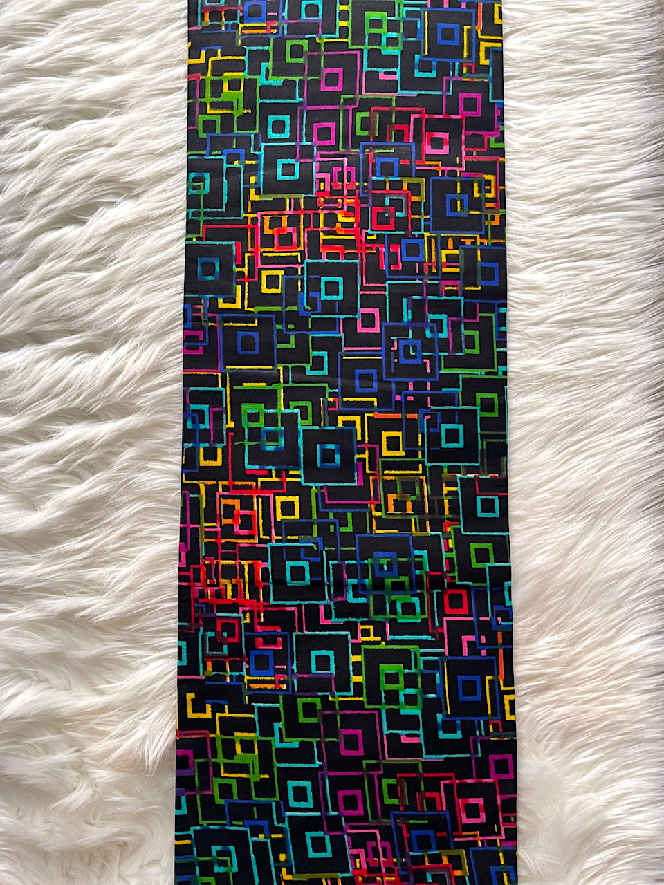 Colorful geometric patterned rug on a white fluffy surface