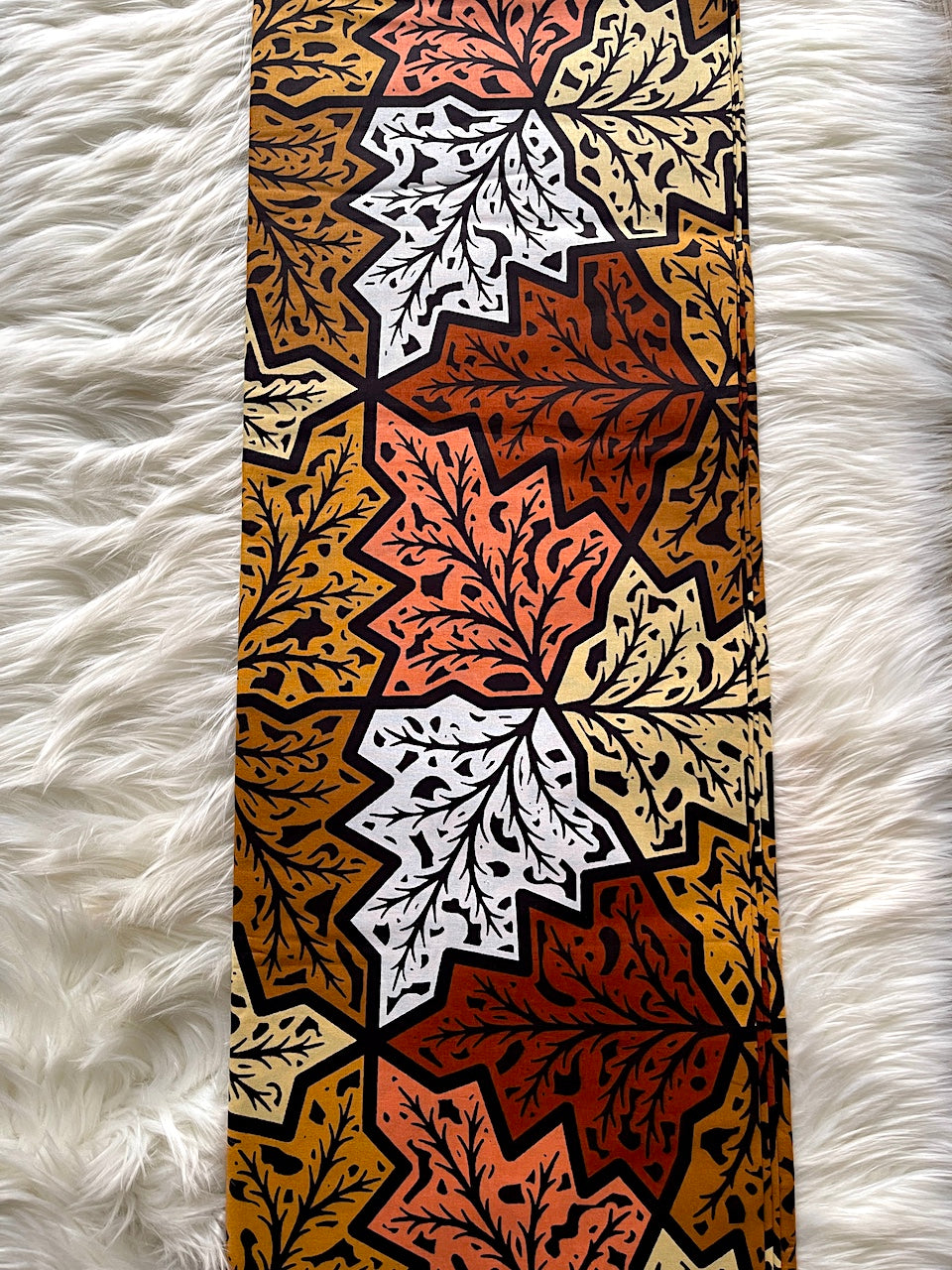 Patterned fabric with autumn leaf design on a white fluffy surface