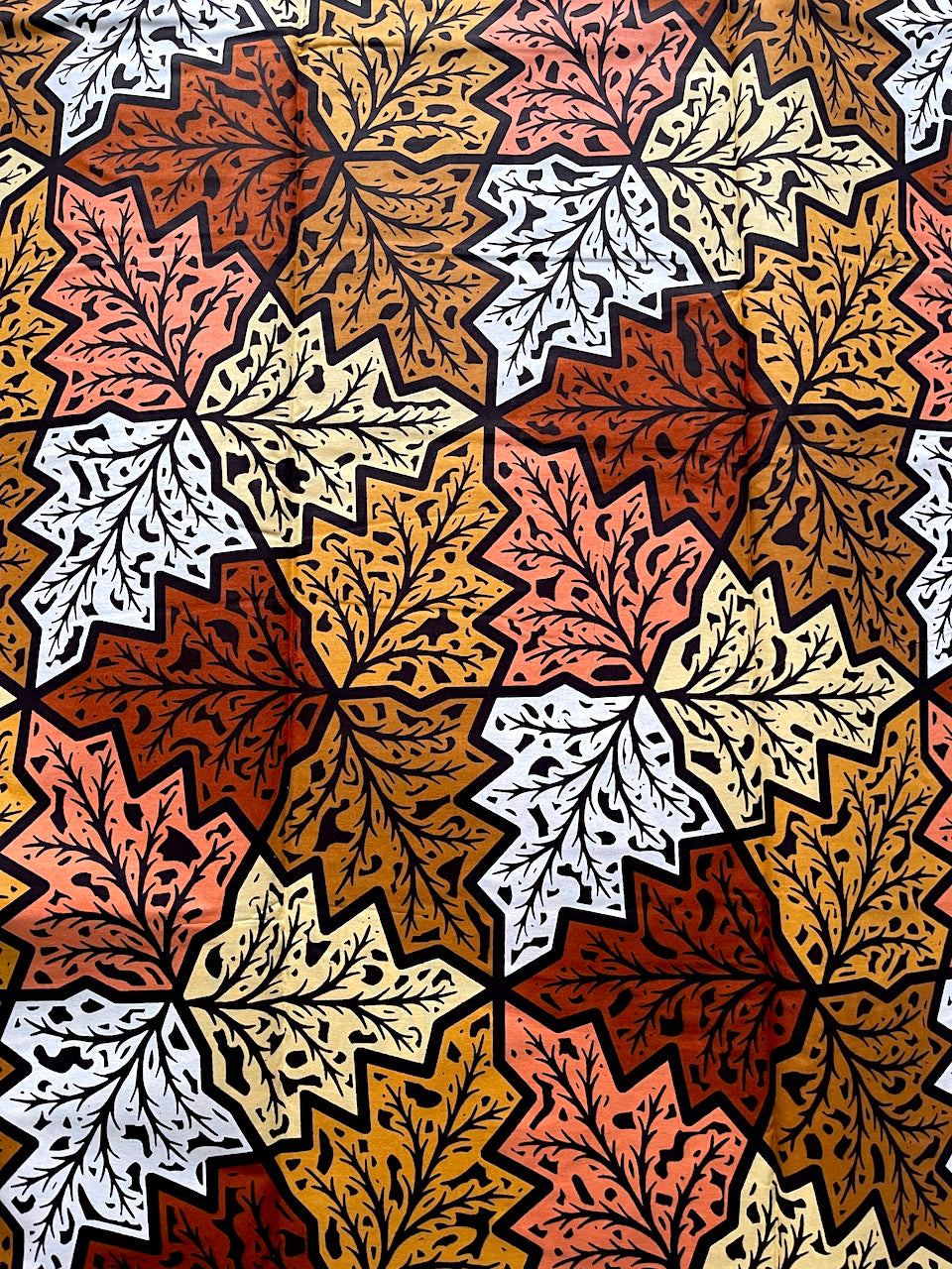 Pattern of autumn leaves in brown, orange, and white on a fabric background