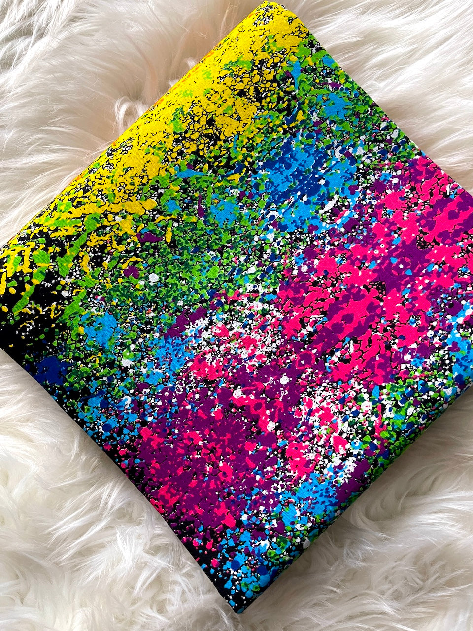 Colorful splatter paint design on a textured surface