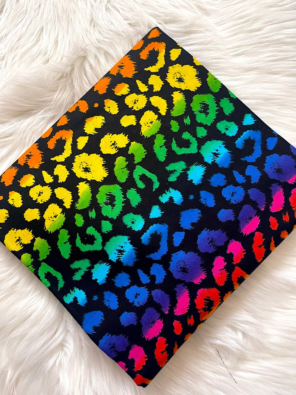 Colorful leopard print fabric on a white fluffy surface
