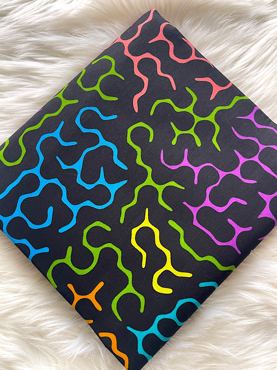 Colorful patterned fabric on a white fluffy surface
