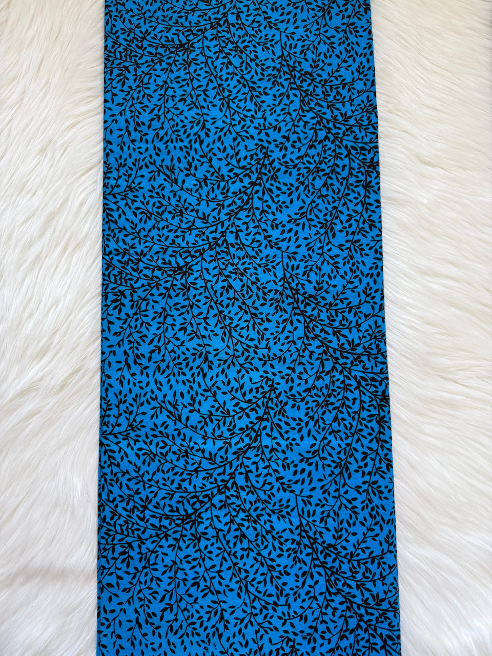 Blue fabric with black pattern on a white textured surface