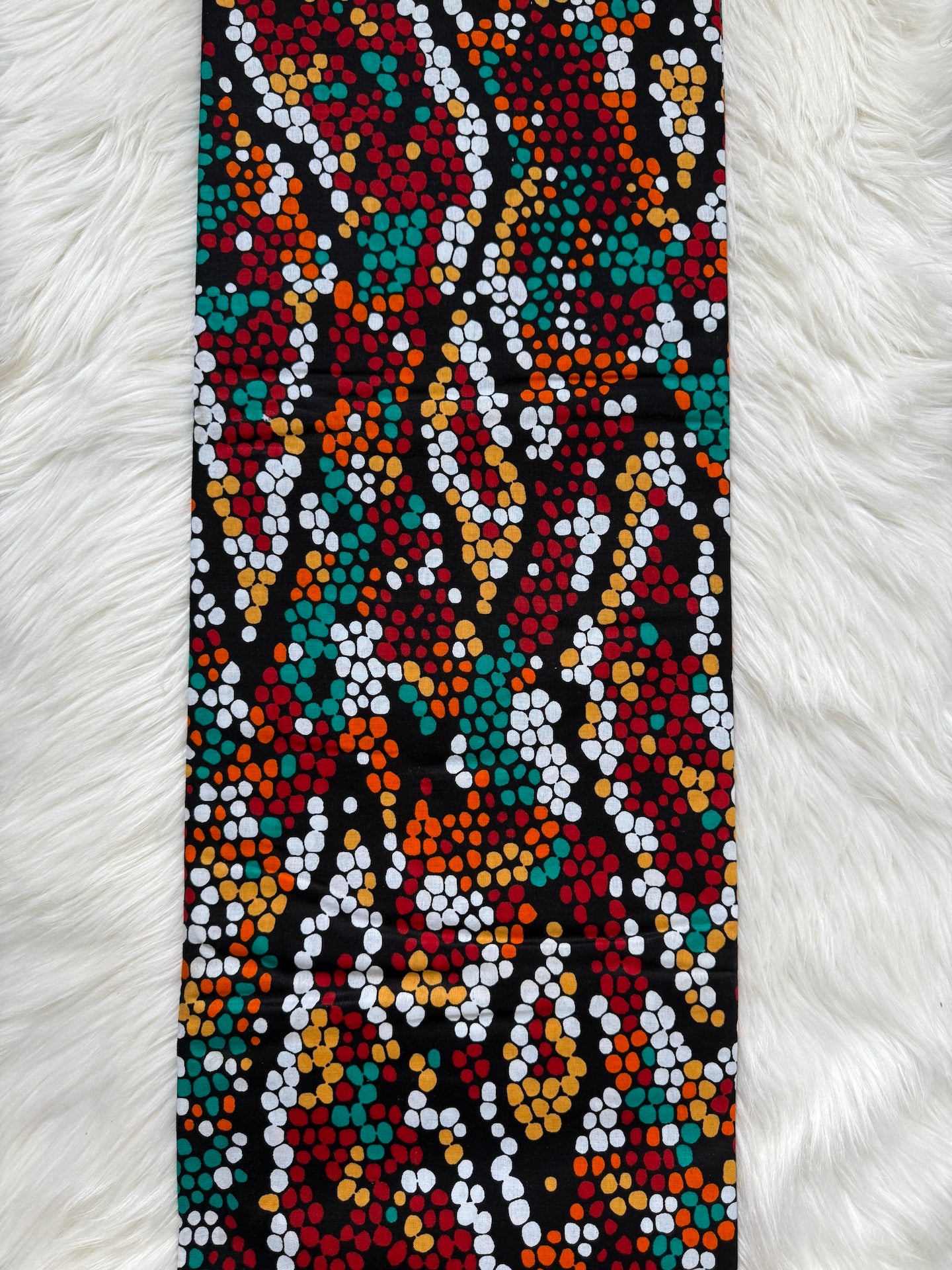 Colorful patterned fabric on a white fur background