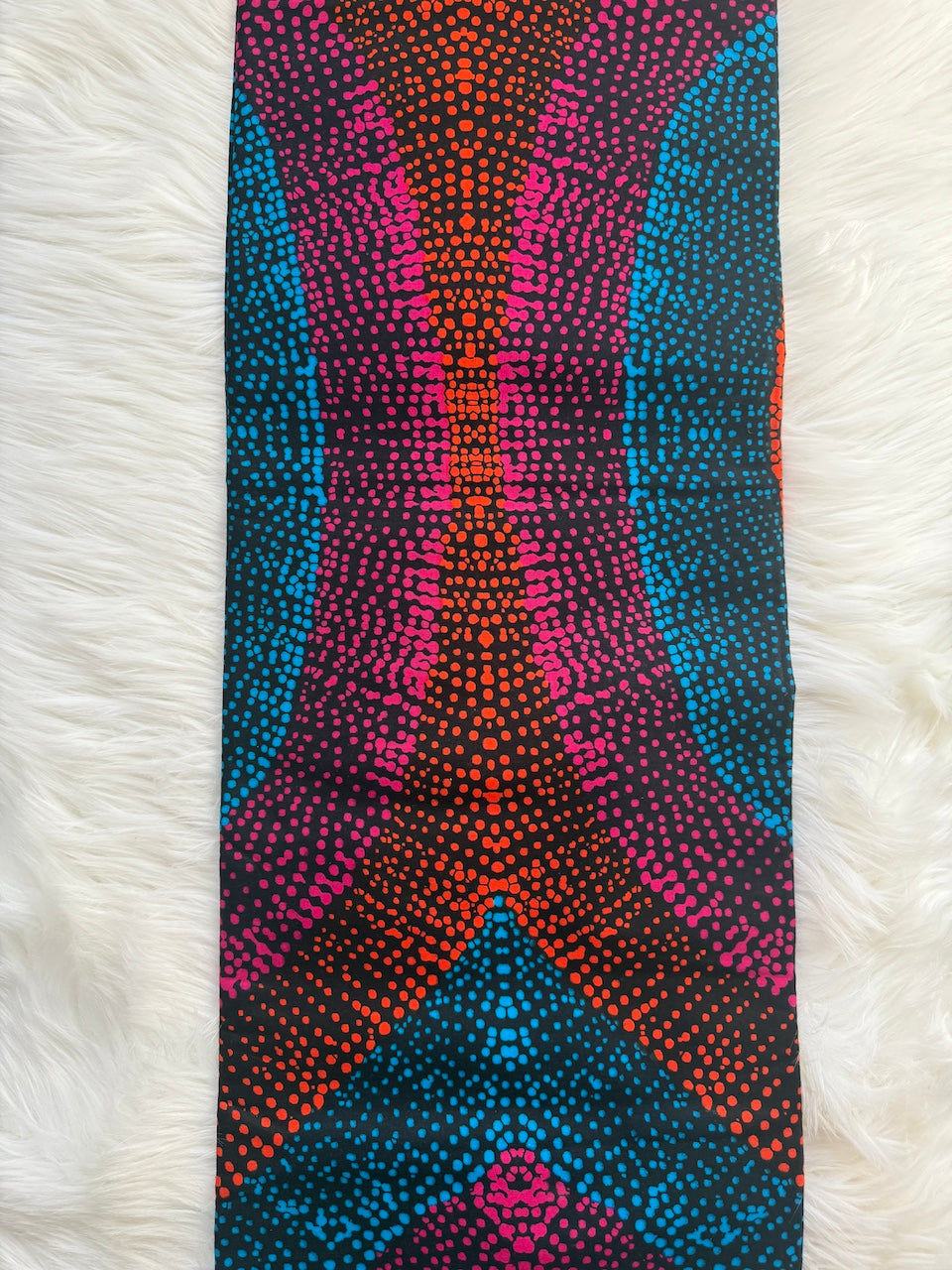 Colorful patterned fabric on a white fur background