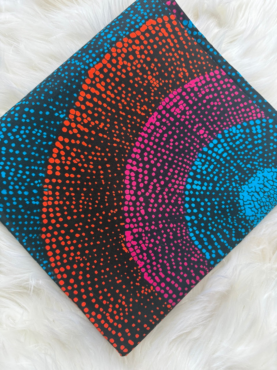 Colorful dot patterned fabric on a white fur background