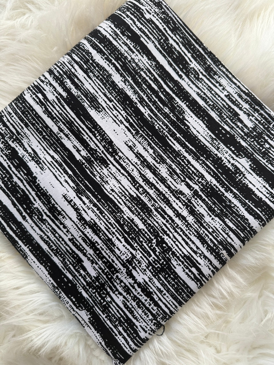 Black and white striped fabric on a fluffy white surface