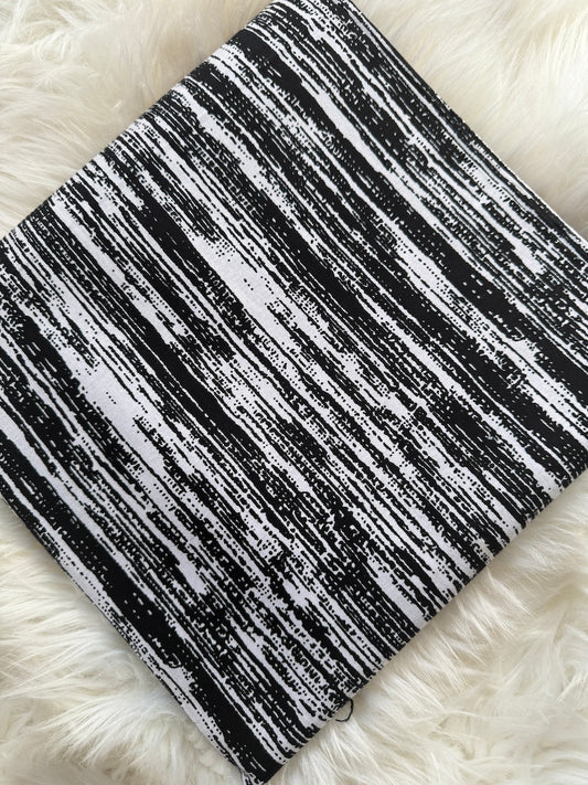 Black and white striped fabric on a fluffy white surface