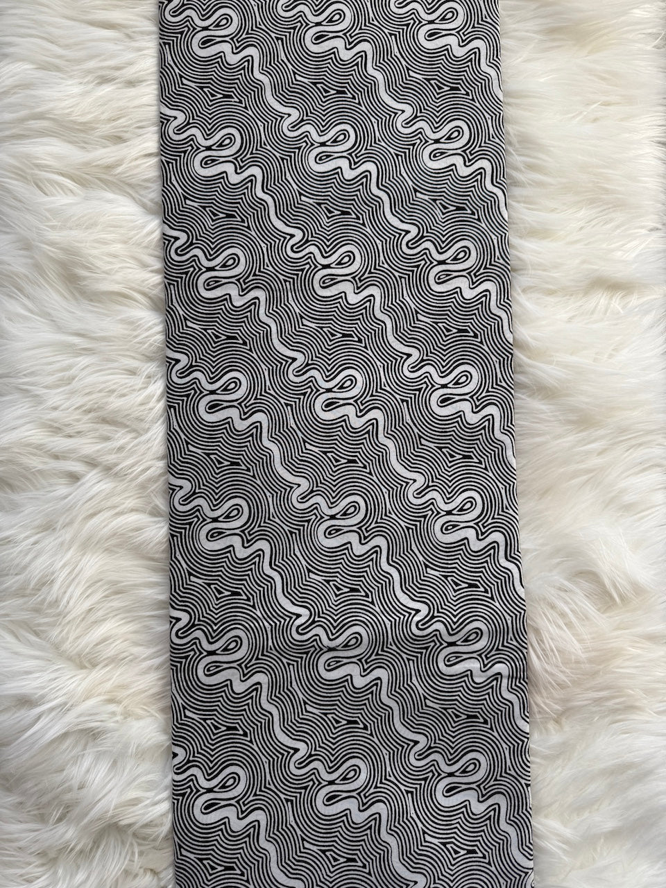 Black and white patterned tie on a fluffy white surface