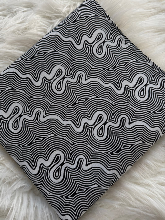 Black and white patterned fabric on a fluffy white surface