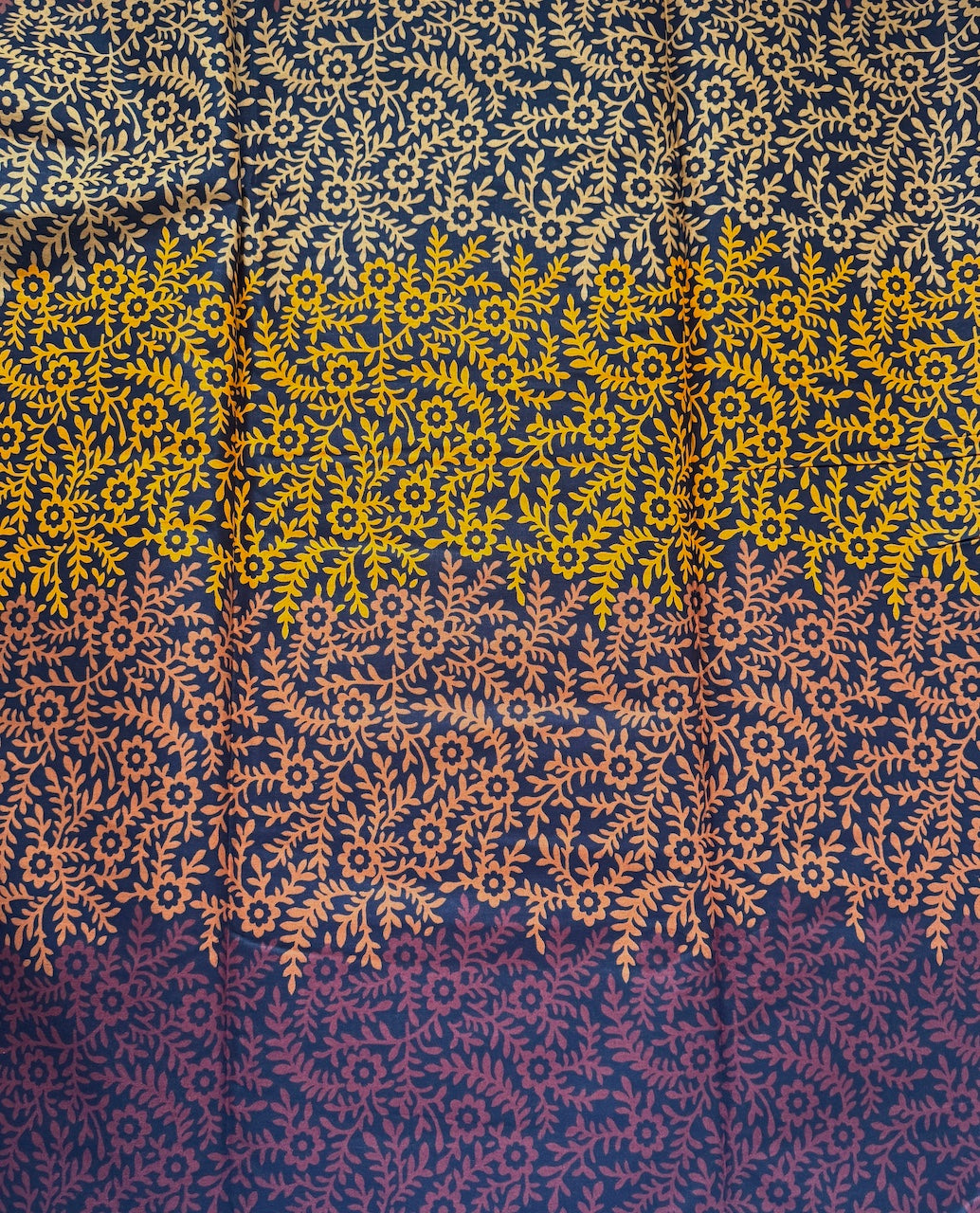 Patterned fabric with yellow and orange designs on a dark blue background
