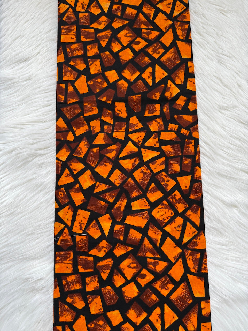 Patterned fabric with orange and brown geometric design on a white background