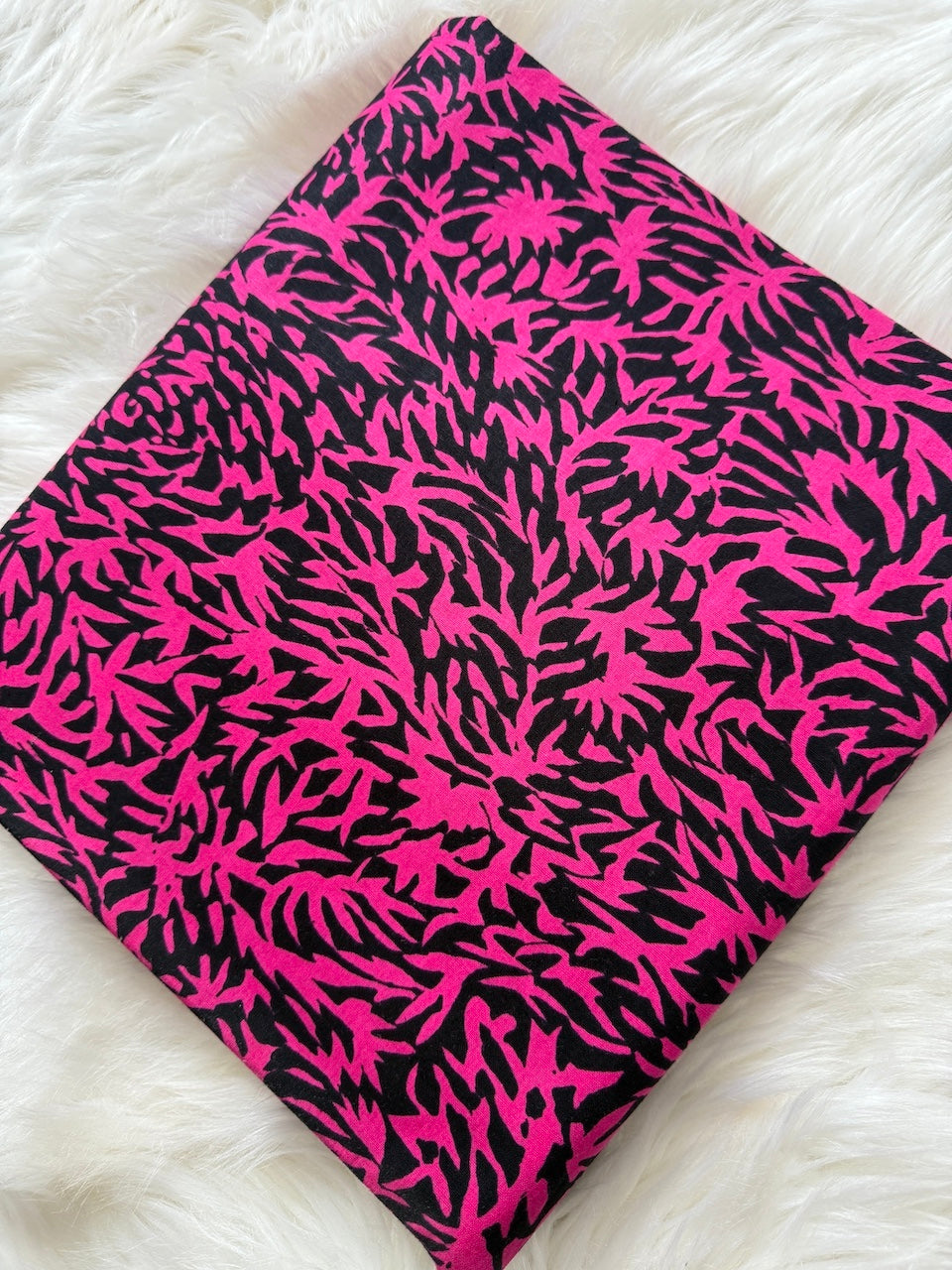 Pink and black patterned fabric on a white surface