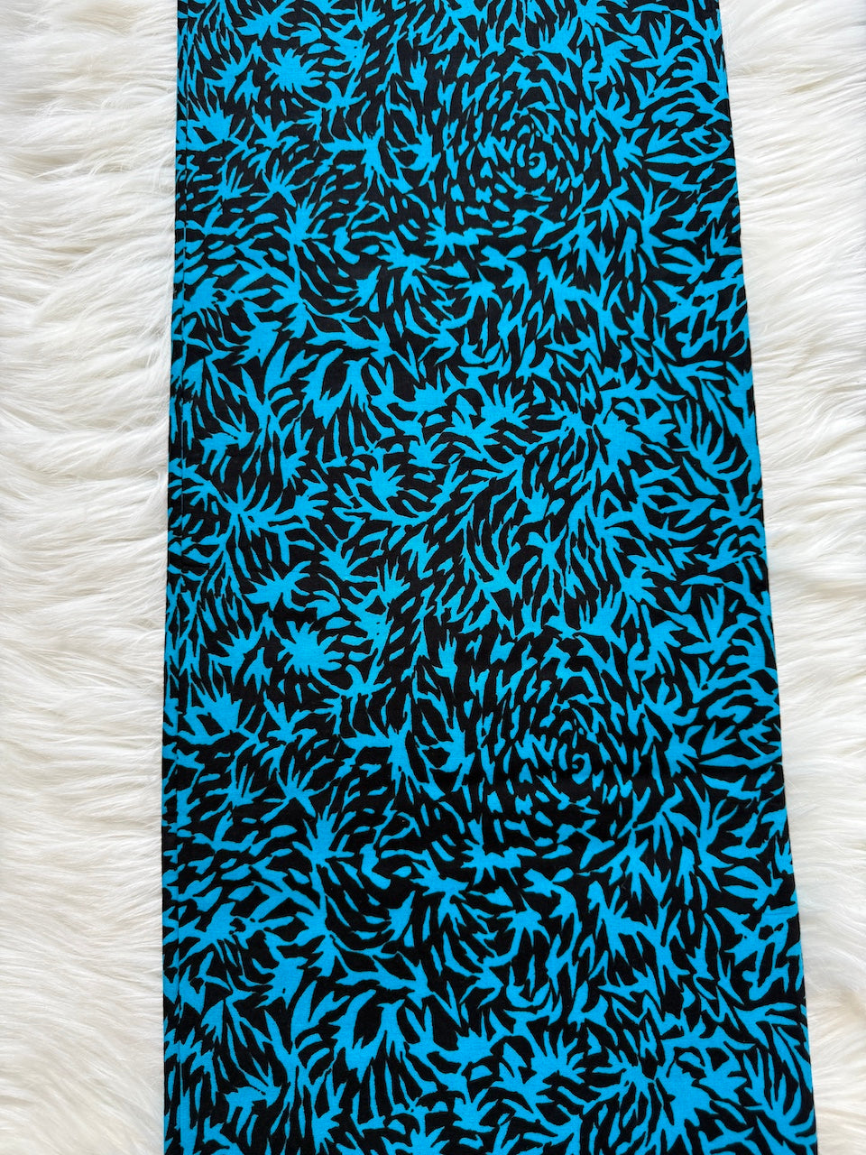 Blue and black patterned fabric on a white textured background