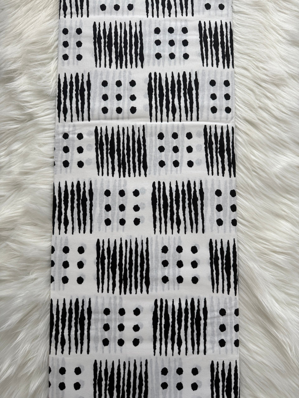 Black and white patterned fabric on a fluffy white surface