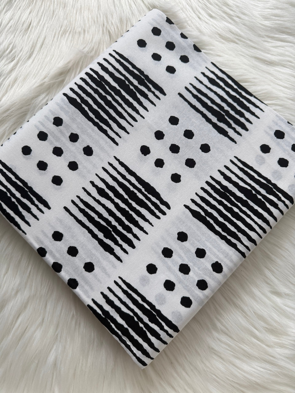 Black and white patterned fabric on a fluffy white surface