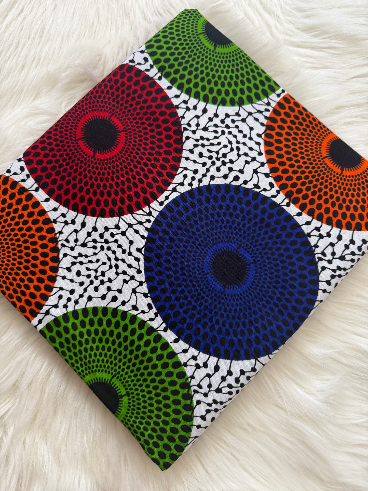 Colorful patterned fabric with circular designs on a white surface